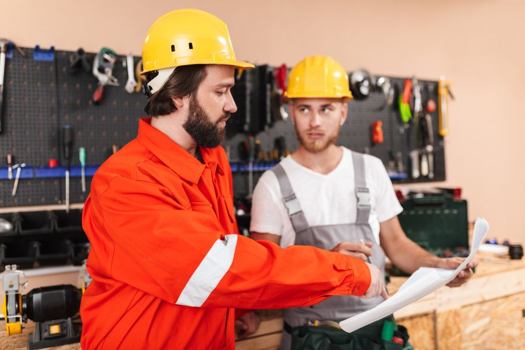 two-builders-work-clothes-yellow-hardhats-working-workshop-with-tools-background.jpg
